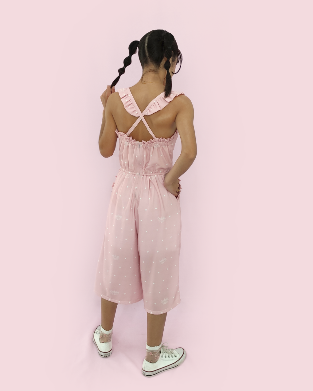 Model wearing pink polyester overalls with heart print by meliekstea