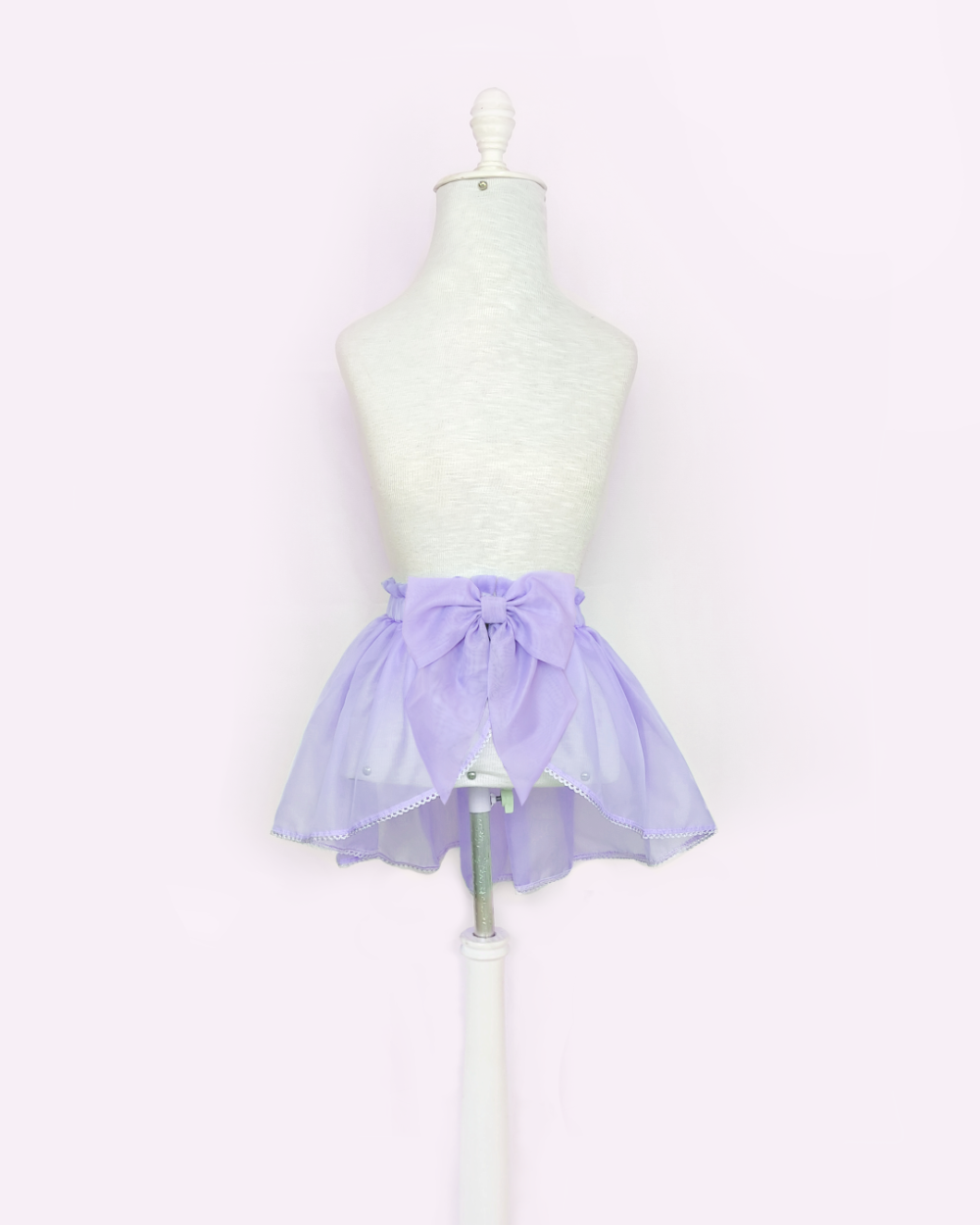Overskirt lavender made of voile, viscose lace and a detachable bow.