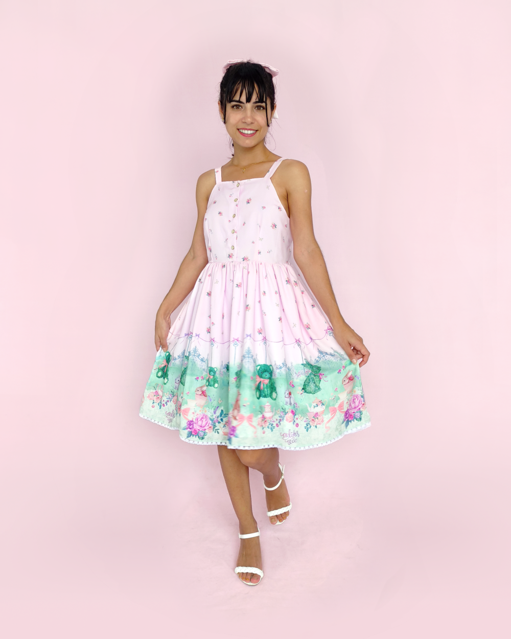 Dress made of pink polyester printed with a garden full of bunnies, teddy bears, cups and teapots, flowers and a beautiful lawn.