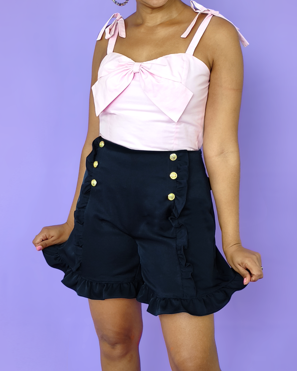 Model wearing navy sailor shorts, with side zipper, back pockets and ruffles everywhere.